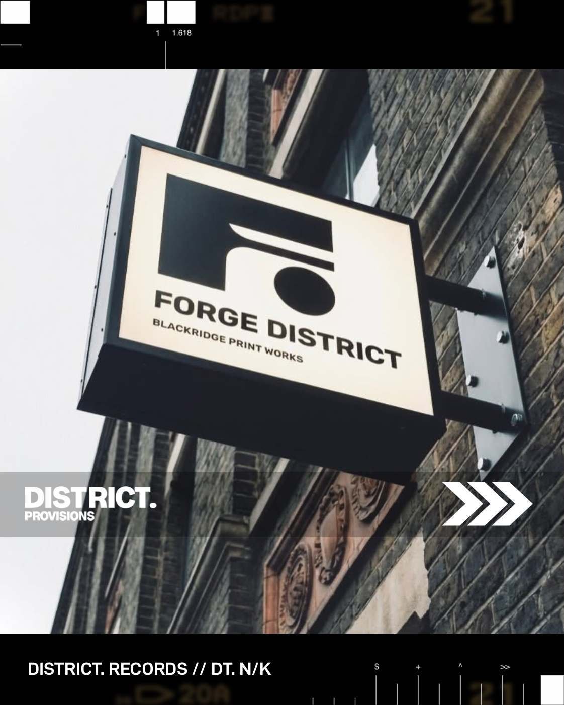 The illuminated FORGE DISTRICT sign against the old Victorian factory brickwork on the Blackridge side of the building.